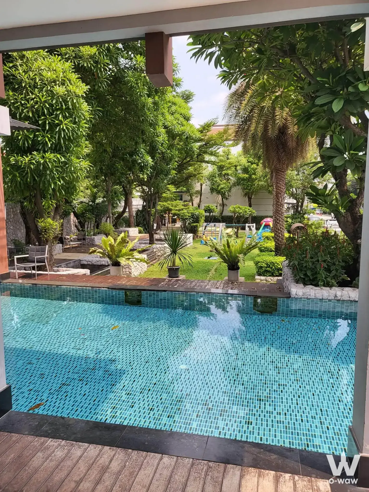 Resort-style outdoor pool with turquoise water and wooden deck at this Baan Klang Muang townhouse rental