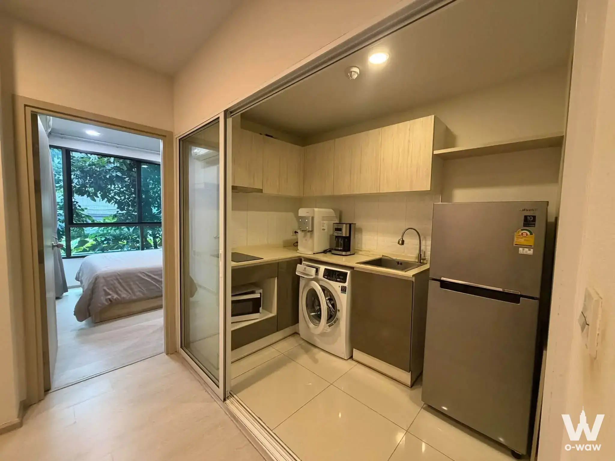 Fully furnished 1-bed condo kitchen in The Tree Sukhumvit 64 with light wood cabinets and stainless steel appliances