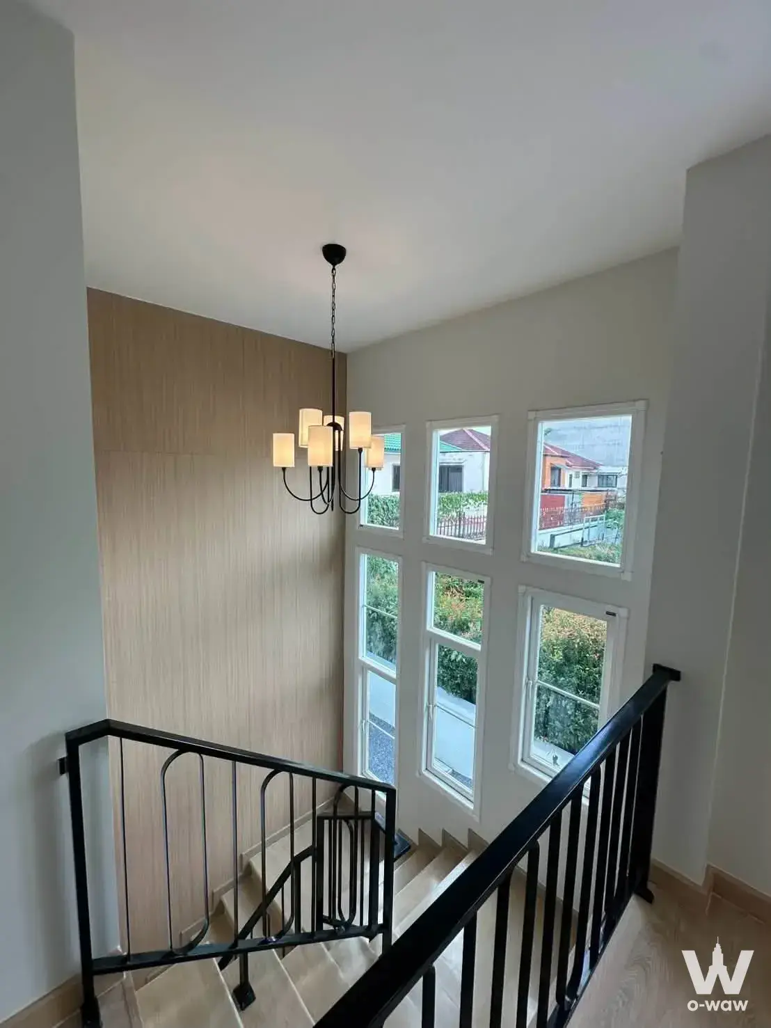 Staircase landing in a 3-bed house for sale in Moo Ban Ratchaphruek with black metal railing and natural light