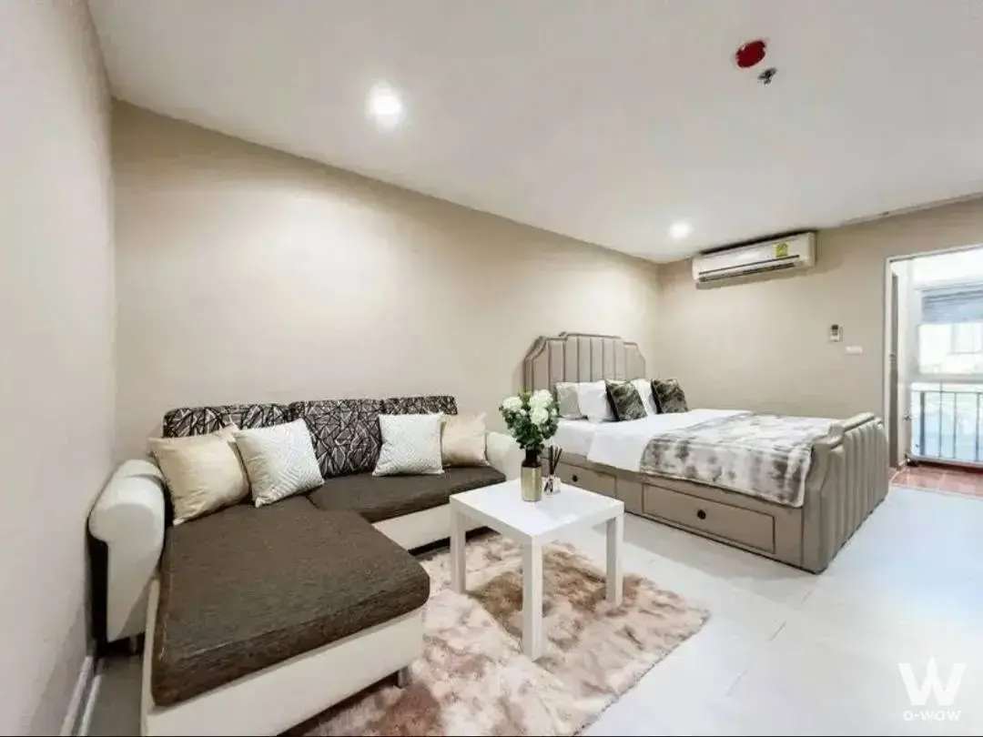 Combined living space featuring L-shaped sofa and queen bed in a 1-bed condo for rent at Condo Regent Home 7/1