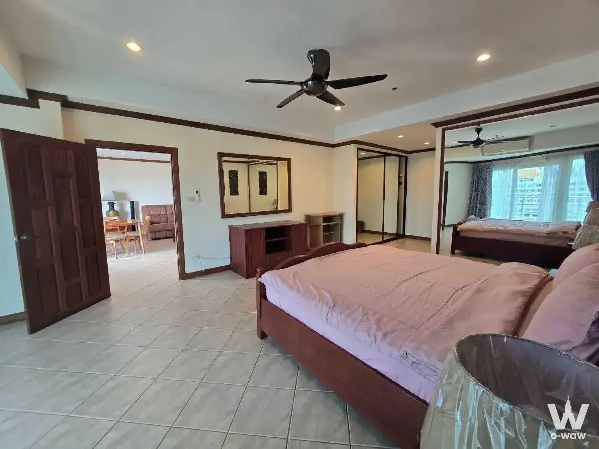 Spacious master bedroom in View Talay 2A for sale, featuring dark wood frame and mirrored wardrobes