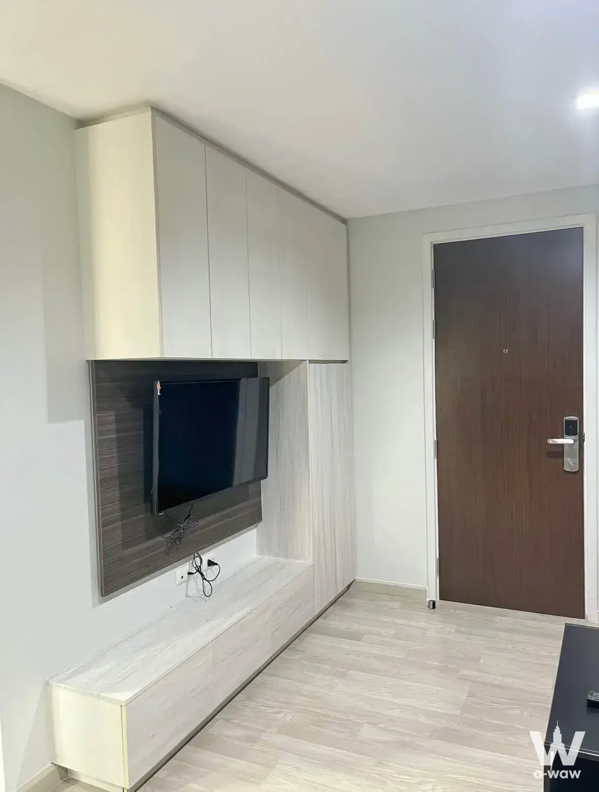 Built-in cabinetry and TV wall in a newly renovated 1-bed condo for sale in The Privacy Pracha Uthit