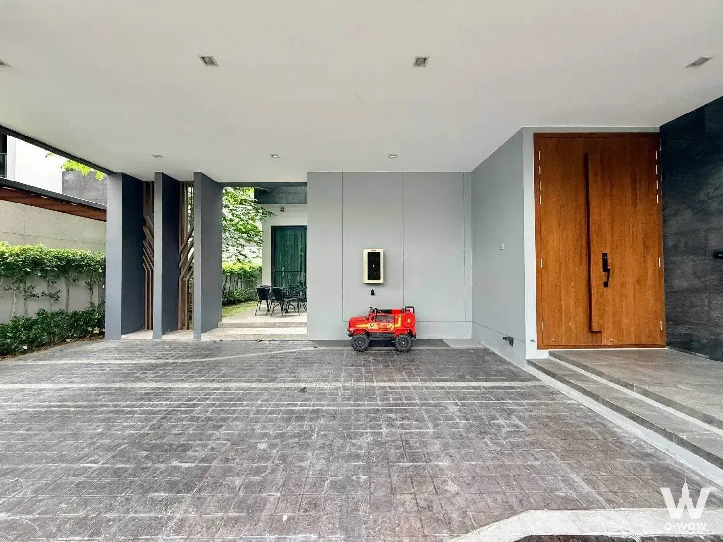 4-bed house for rent in The Gentry Phatthanakan 2, showing a covered carport with grey pavers and contemporary exterior