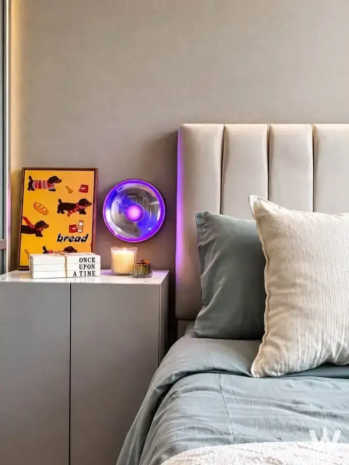 This bedroom in a one-bedroom Lumpini Seaview Jomtien condo has purple LED headboard glow and styled nightstand