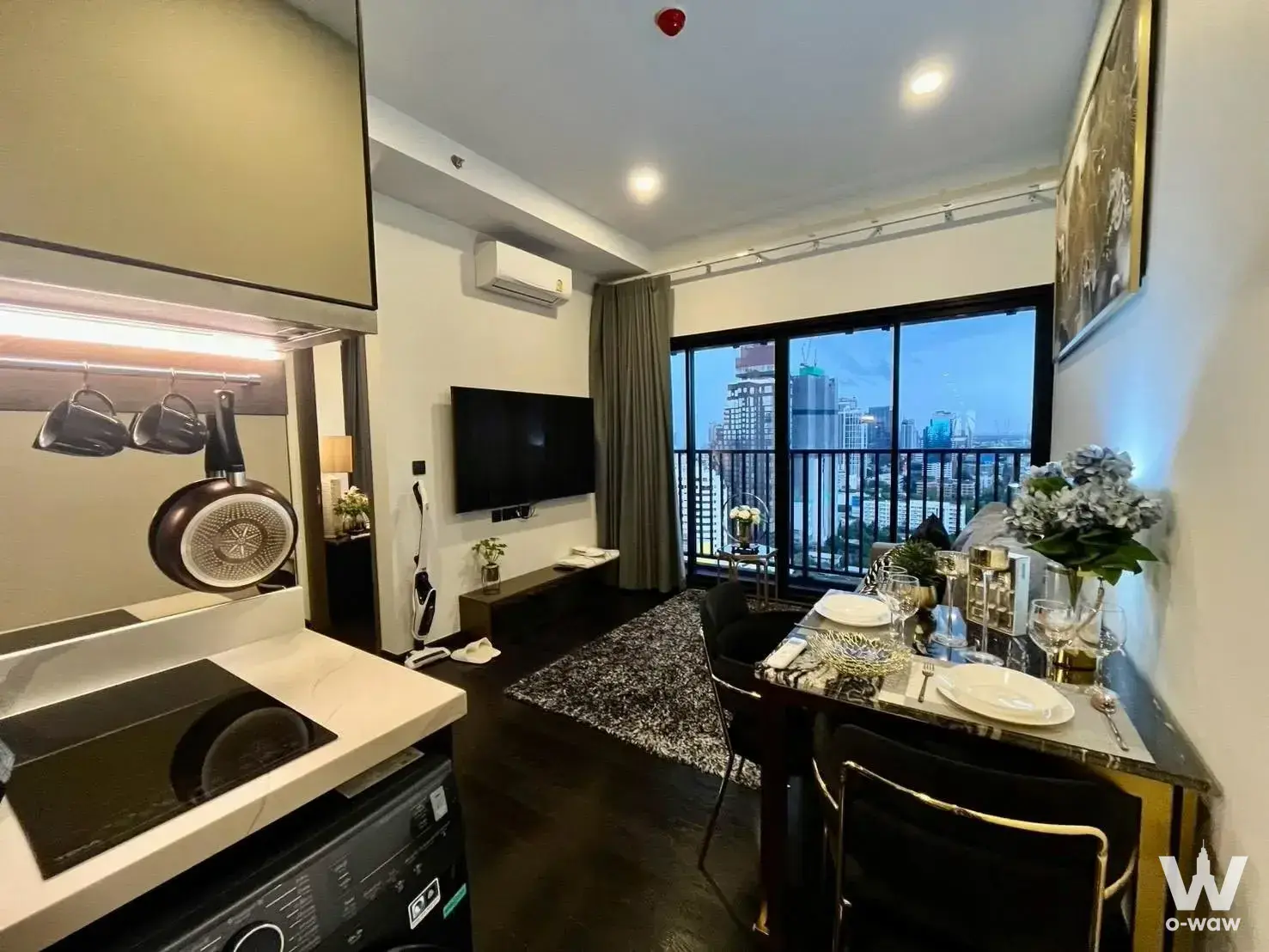 Open-plan living area in Park Origin Thonglor featuring a marble dining set and city view