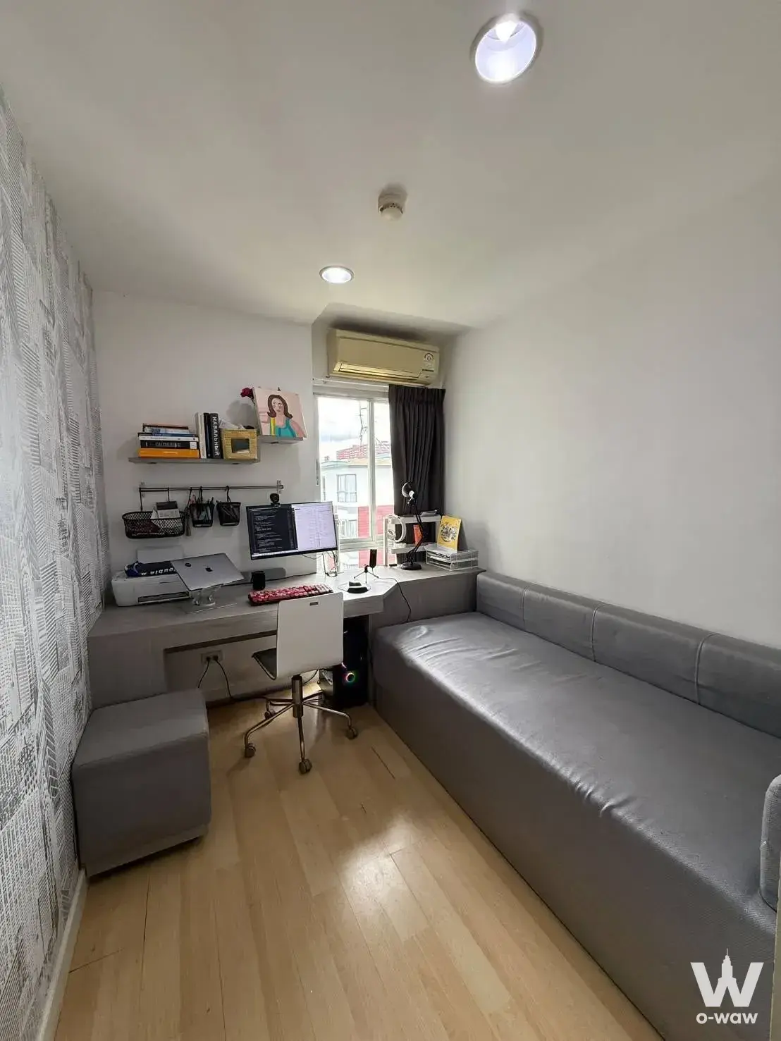 Home office in 1-bed condo for rent in Punnawithi with L-shaped desk and futon sofa