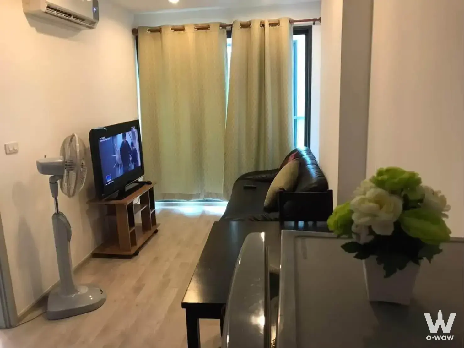 Living area of an Ideo Mobi Charan Interchange rental with black leather sofa and wooden coffee table
