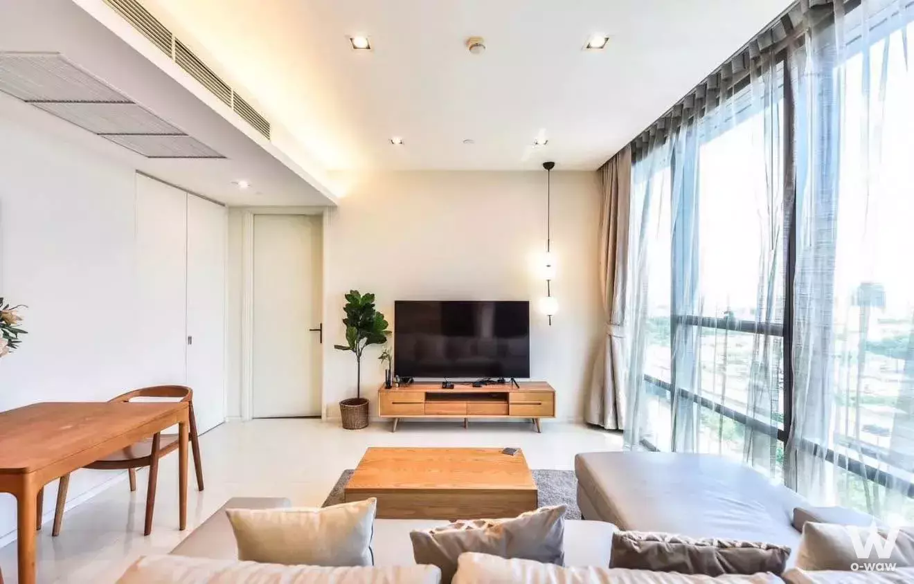 Bright living room in a 1-bed condo at The Bangkok Sathorn with L-shaped sofa and floor-to-ceiling windows
