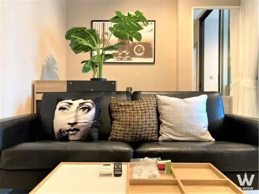 Life Asoke Rama 9 living room with black leather sofa and Monstera plant