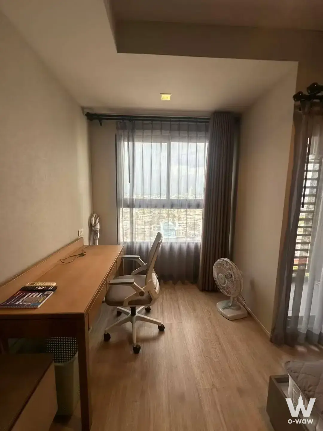 Ideo Sathon-Wongwian Yai home office nook with oak desk and city skyline view