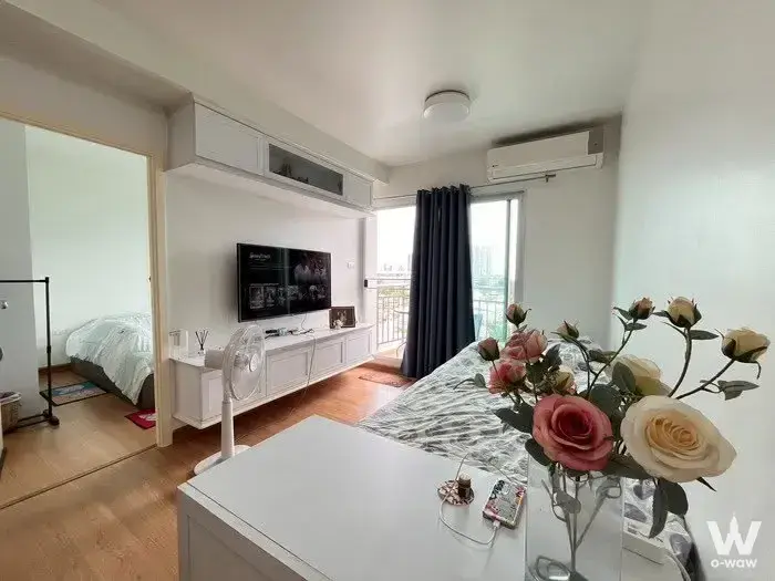 Master bedroom in a 2-bed condo for sale in Supalai Veranda with a queen bed, wall-mounted TV and balcony door