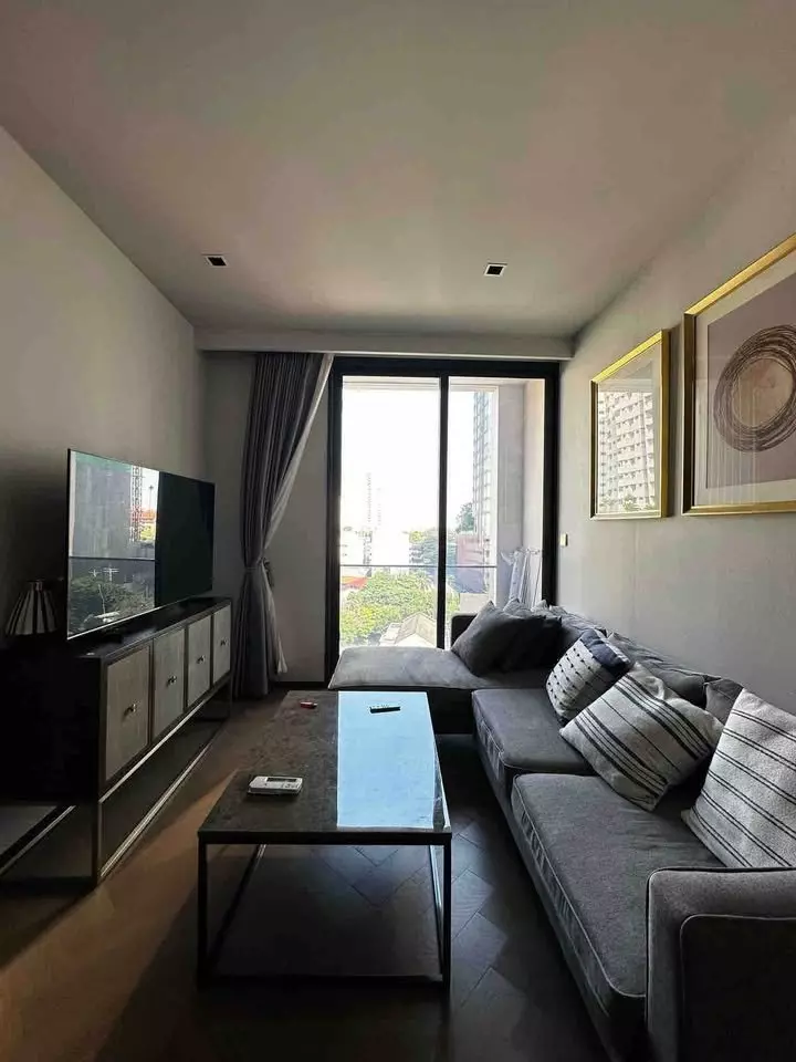 Spacious living room in THE RESERVE 61 HIDEAWAY with an L-shaped grey sectional and floor-to-ceiling balcony doors