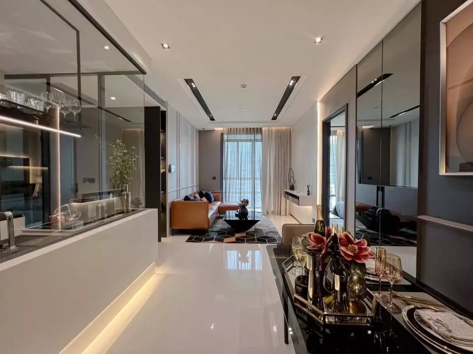 Luxury open-plan living area with marble floors, black dining table, and city views in a 2-bed condo for rent at The Bangkok