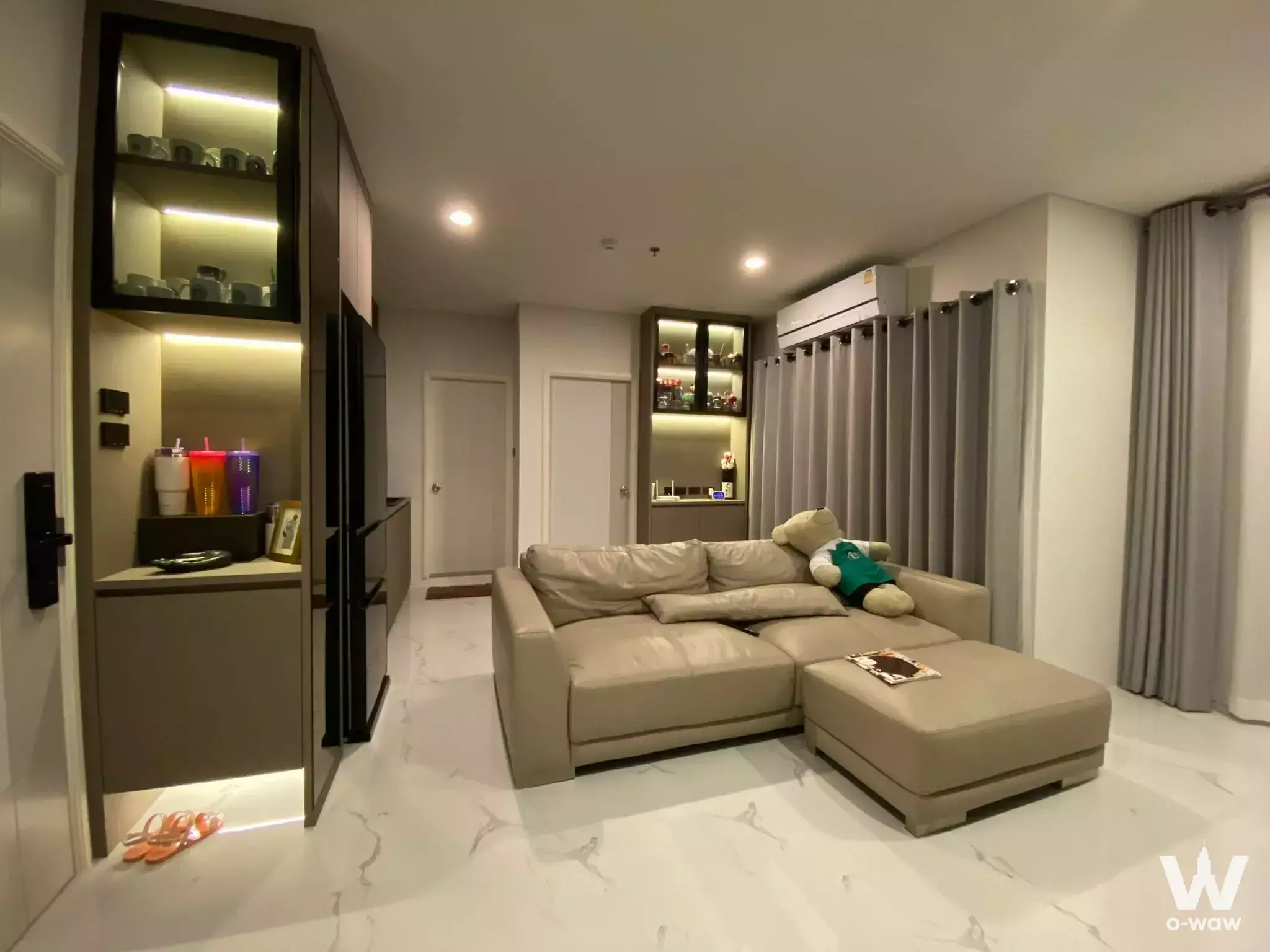 Beige leather sectional sofa in the living room of a 1-bed condo for sale in Lumpini Place Rama 3 - Riverview