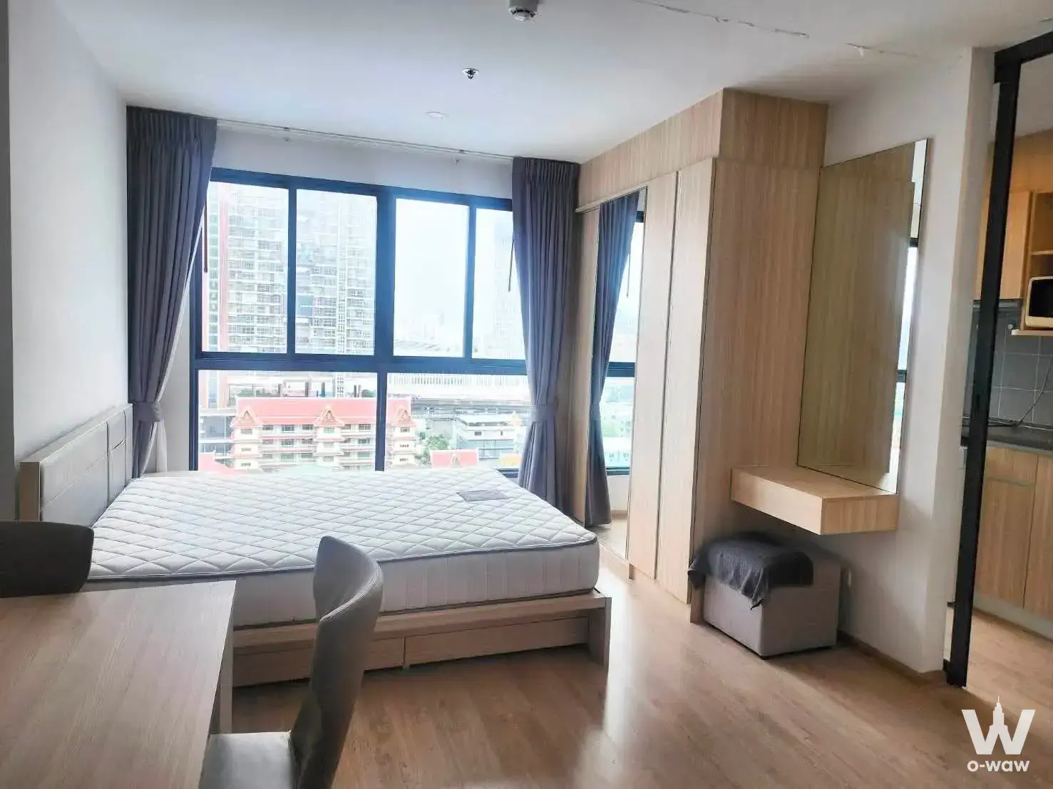 Bedroom in the Ideo O2 1-bed condo with built-in wardrobe and panoramic city views from the window