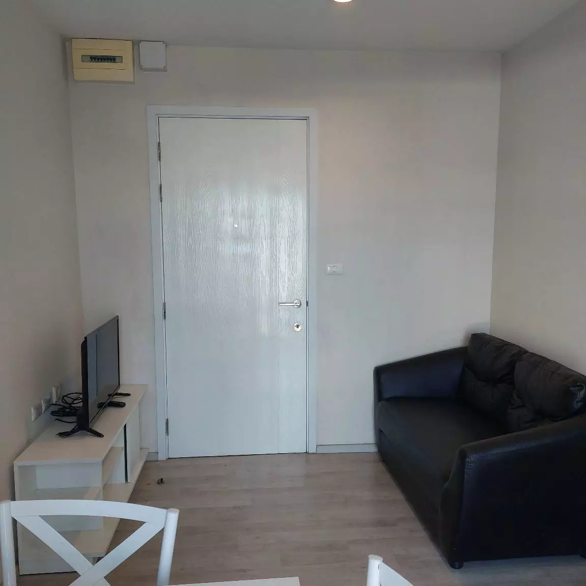 1-bed condo for sale in Plum Condo Central Station Phase 1 with beige laminate flooring and a black leather sofa