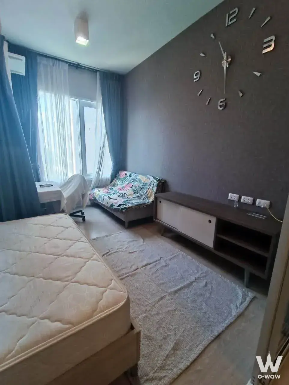 Chapter One Eco Ratchada-HuaiKhwang studio apartment with queen bed, dark accent wall, and blue drapes