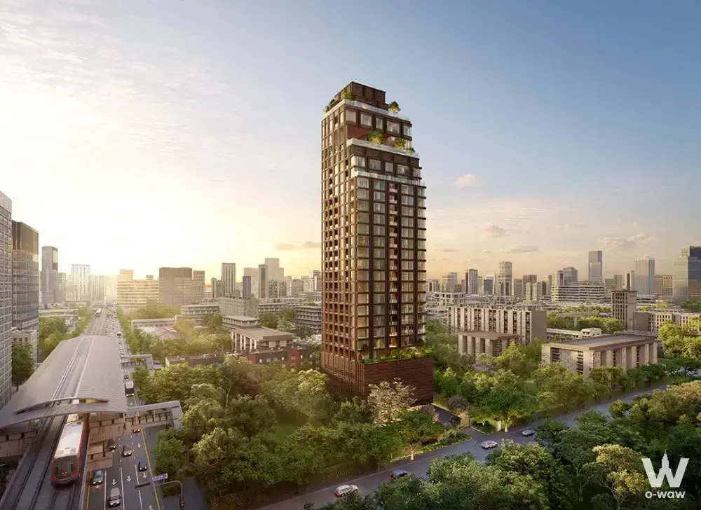 The Monument Sathon 2-bed condo for sale, featuring a dark brick facade and rooftop garden