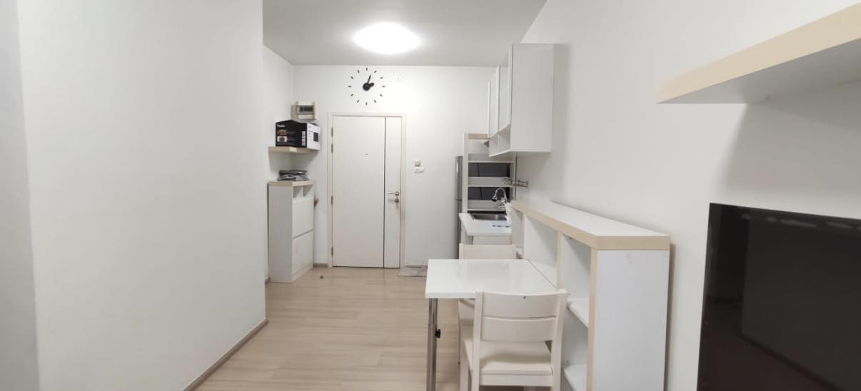 Open-plan studio kitchenette in an A Space Condominium with compact counter and drop-leaf dining table