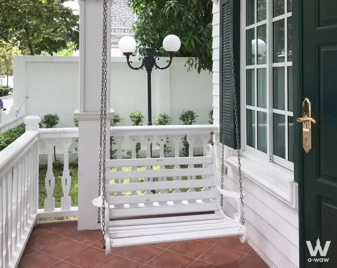Colonial porch of a 4-bed house in Fantasia Villa2 with a white swing bench and terracotta tile floor