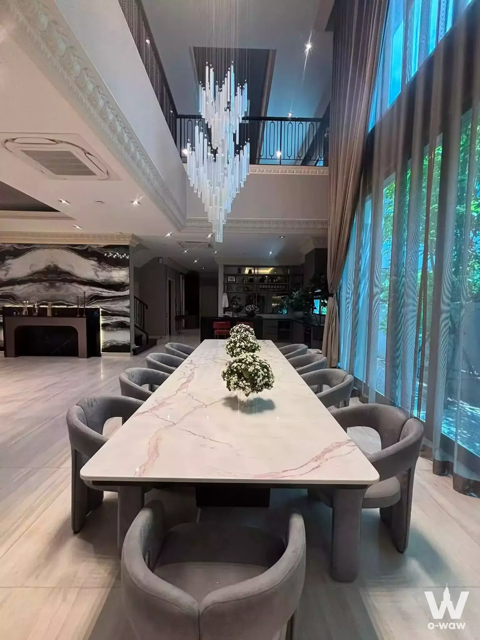 Double-height dining room in Grand Bangkok Boulevard Sathorn with marble table and glass chandelier