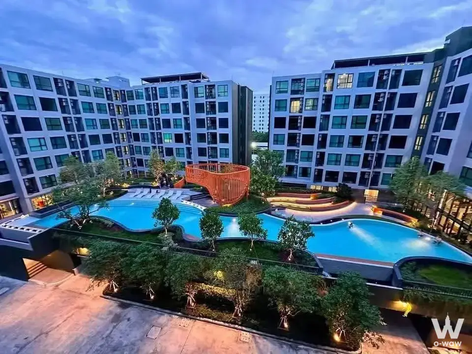 Courtyard pool at Kave Luminous Bangmod featuring an orange lattice sculpture bridge at twilight