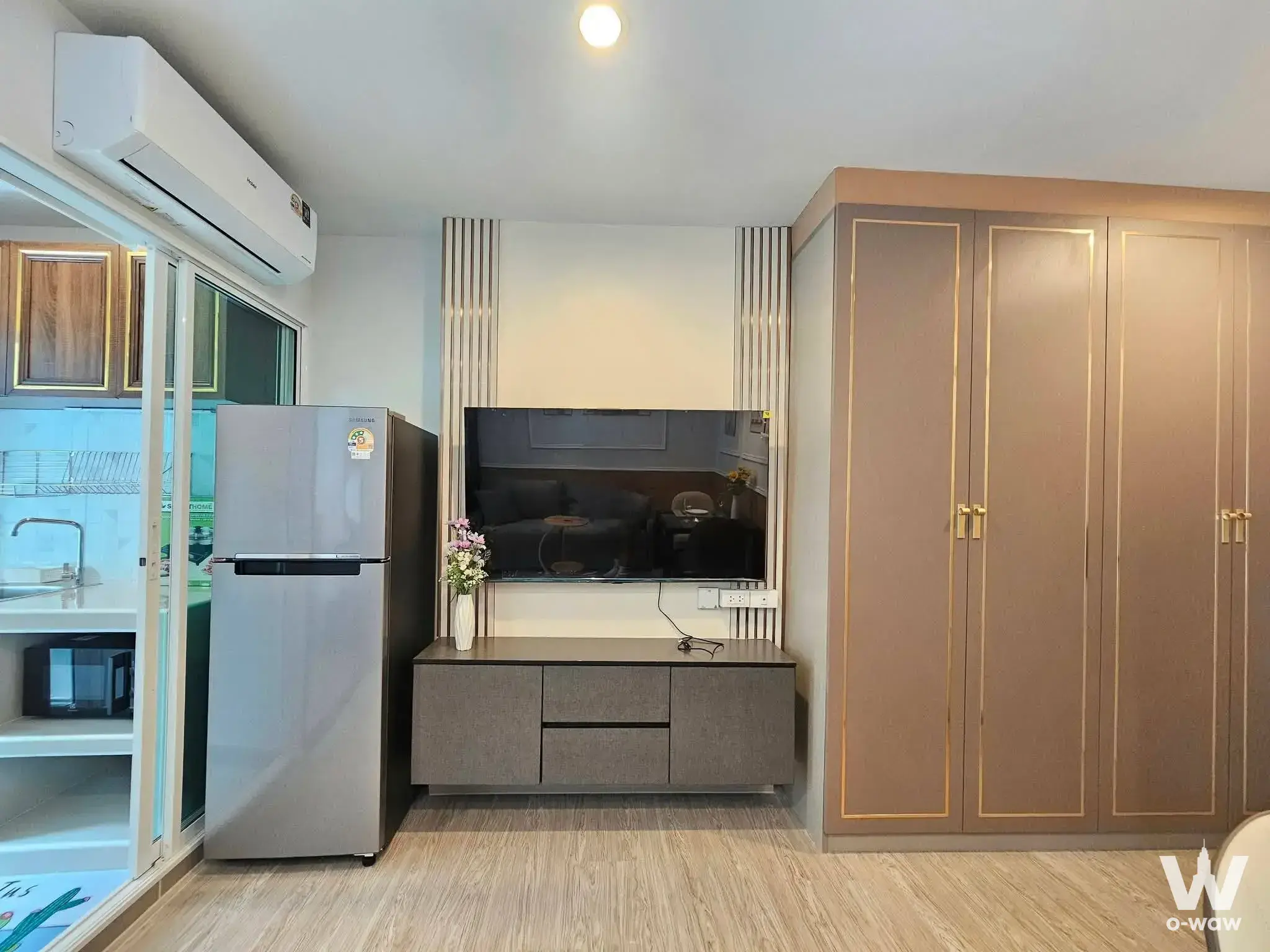Studio at Regent Home Bangna with light wood floors and a gold-trimmed built-in wardrobe