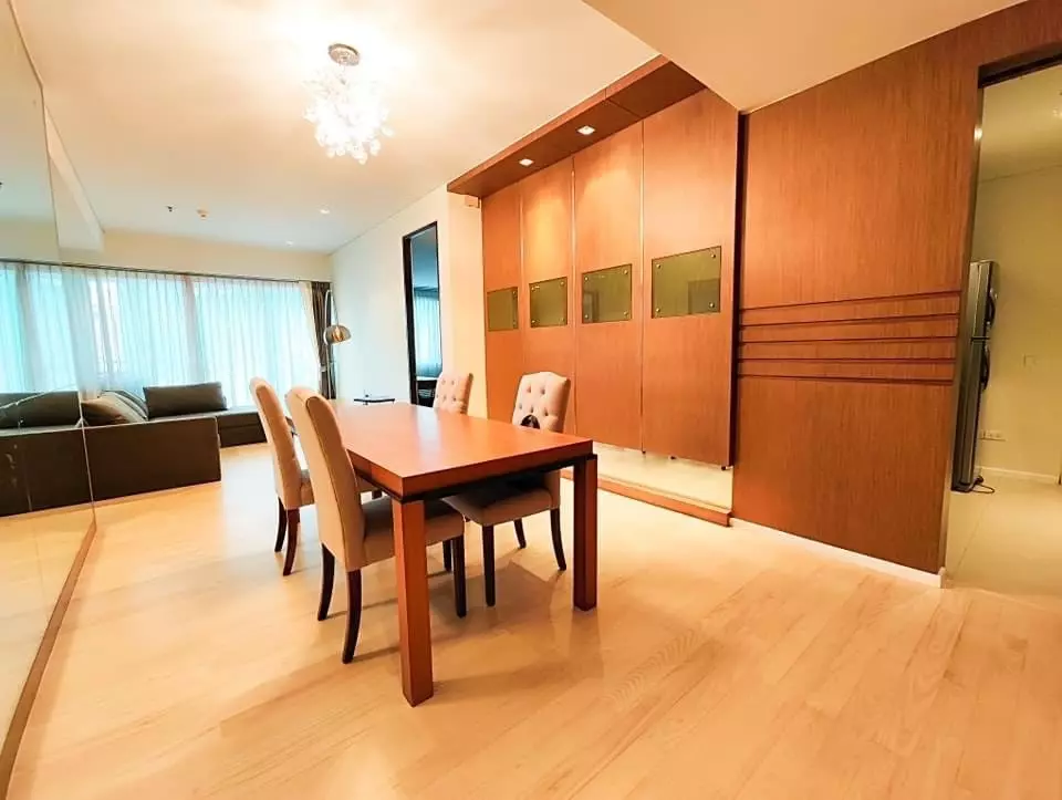 Dining area with brass-accented cabinetry and crystal chandelier in a 2-bed condo for sale at The Lakes