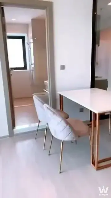 Minimalist dining table with beige chairs in a 2-bed condo for rent at Life Asoke Rama 9