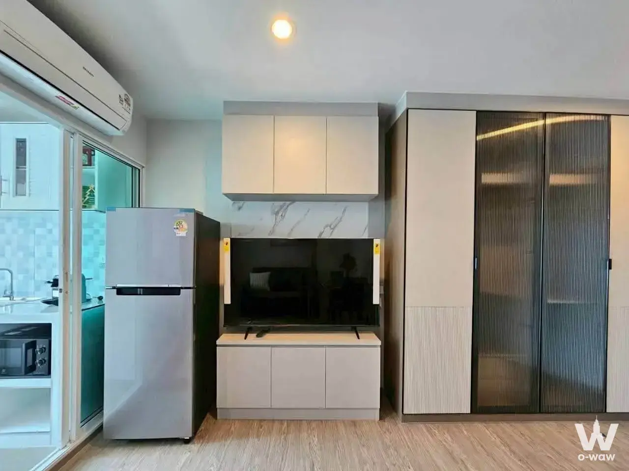 Living area with cream media unit and fluted wardrobe in Regent Home Bangna