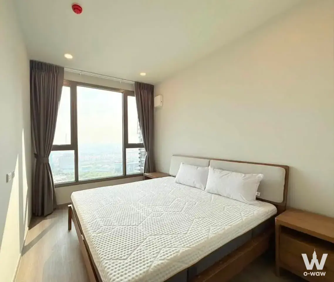 Bright bedroom in a Whizdom The Forestias rental featuring a queen bed and floor-to-ceiling windows with city views