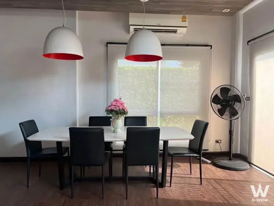 Dining room in Perfect Place Sukhumvit 77 rental with a white table, black chairs, and red-lined dome pendant lights