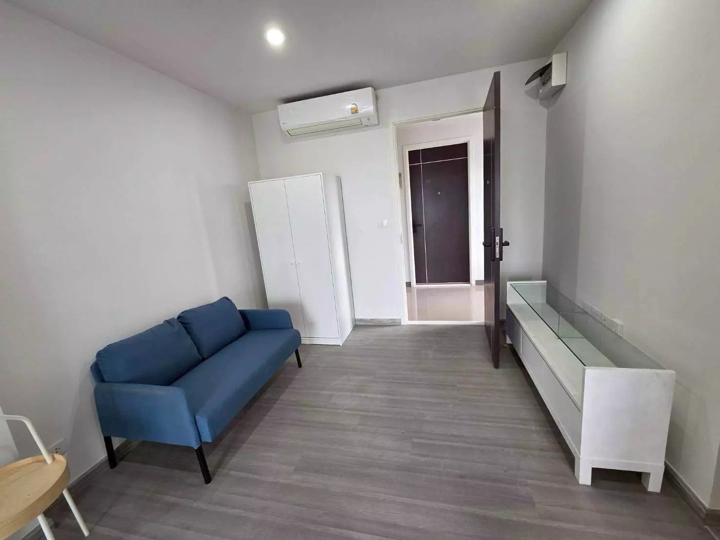 Minimal living room in The President Charan-Yaek Fai Chai Station 1-bed condo with blue sofa and white wardrobe