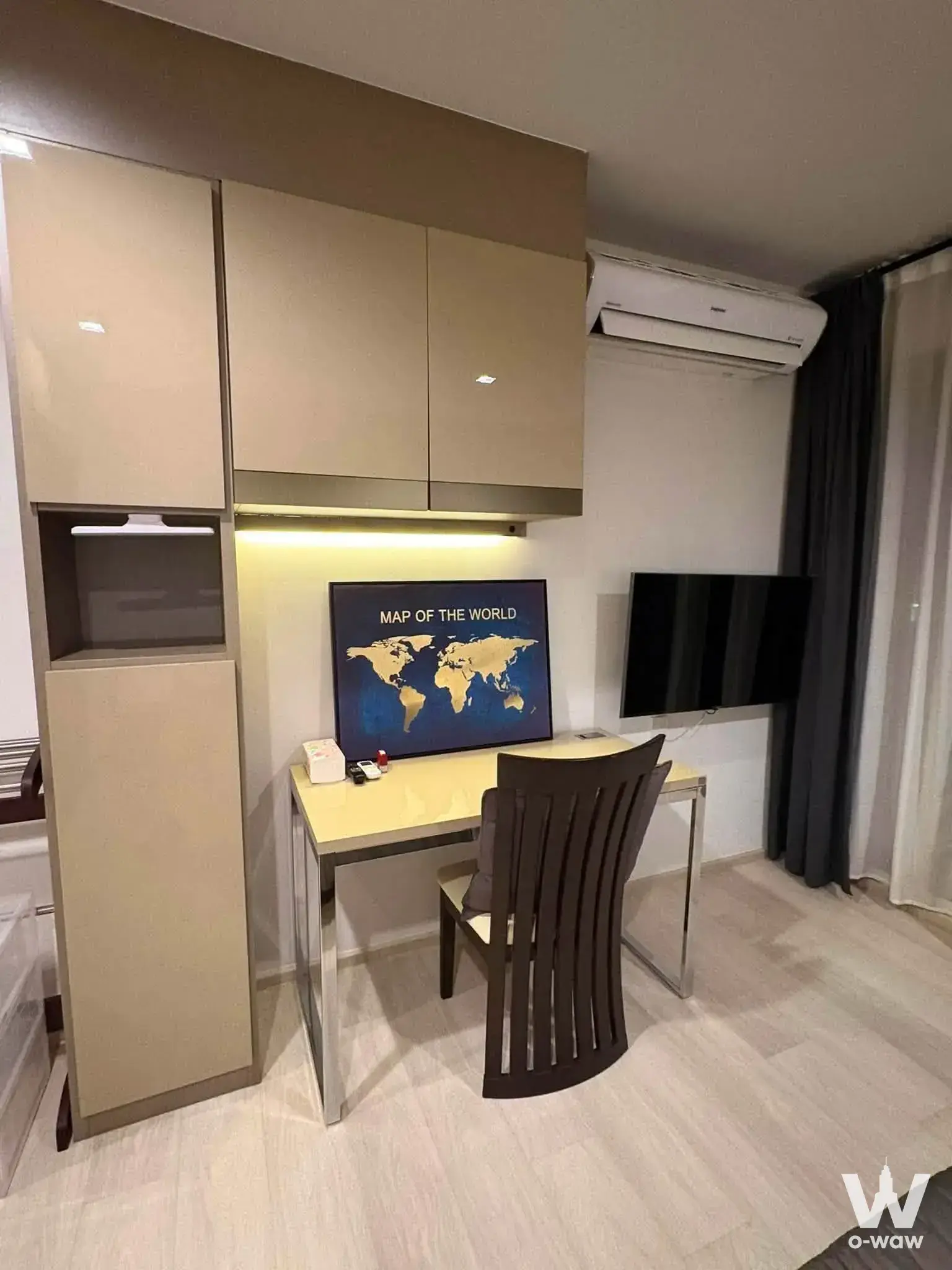 Bedroom corner in a Life One Wireless 1-bed rental with built-in beige cabinetry and a light wood desk