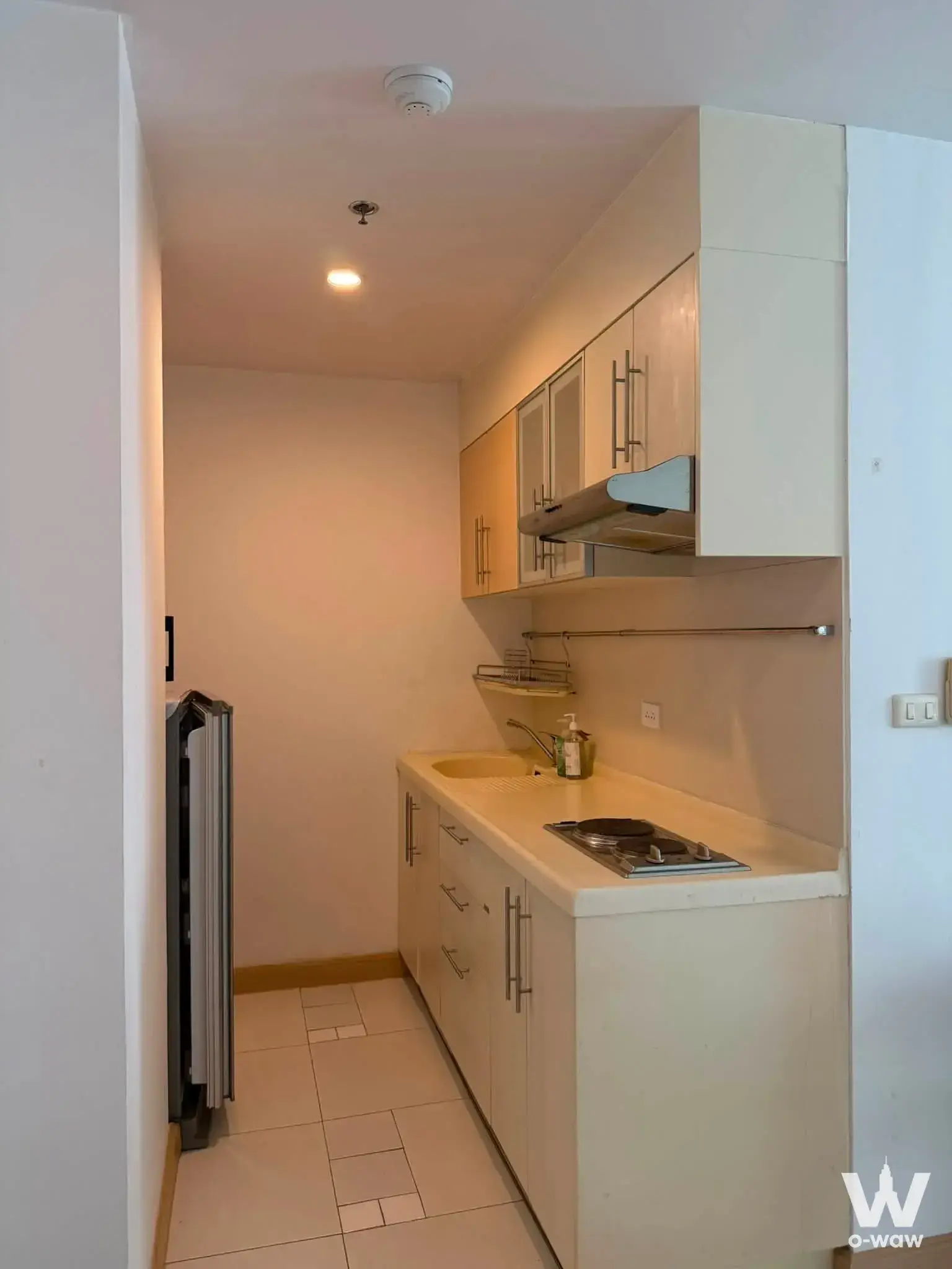 Compact galley kitchen with cream cabinets and gas cooktop in Supalai River Place