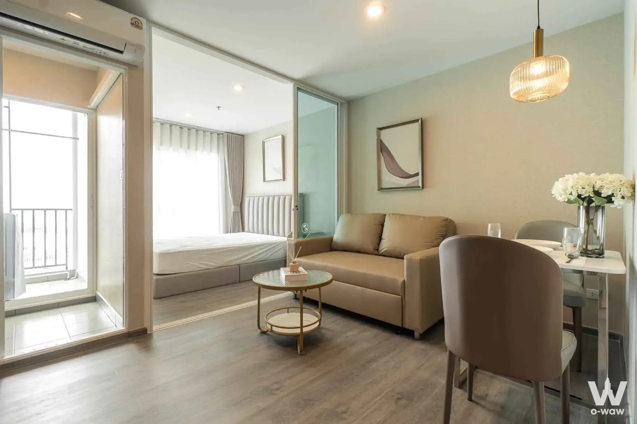 Regent Home Bangna studio apartment featuring taupe sofa and glass dining table