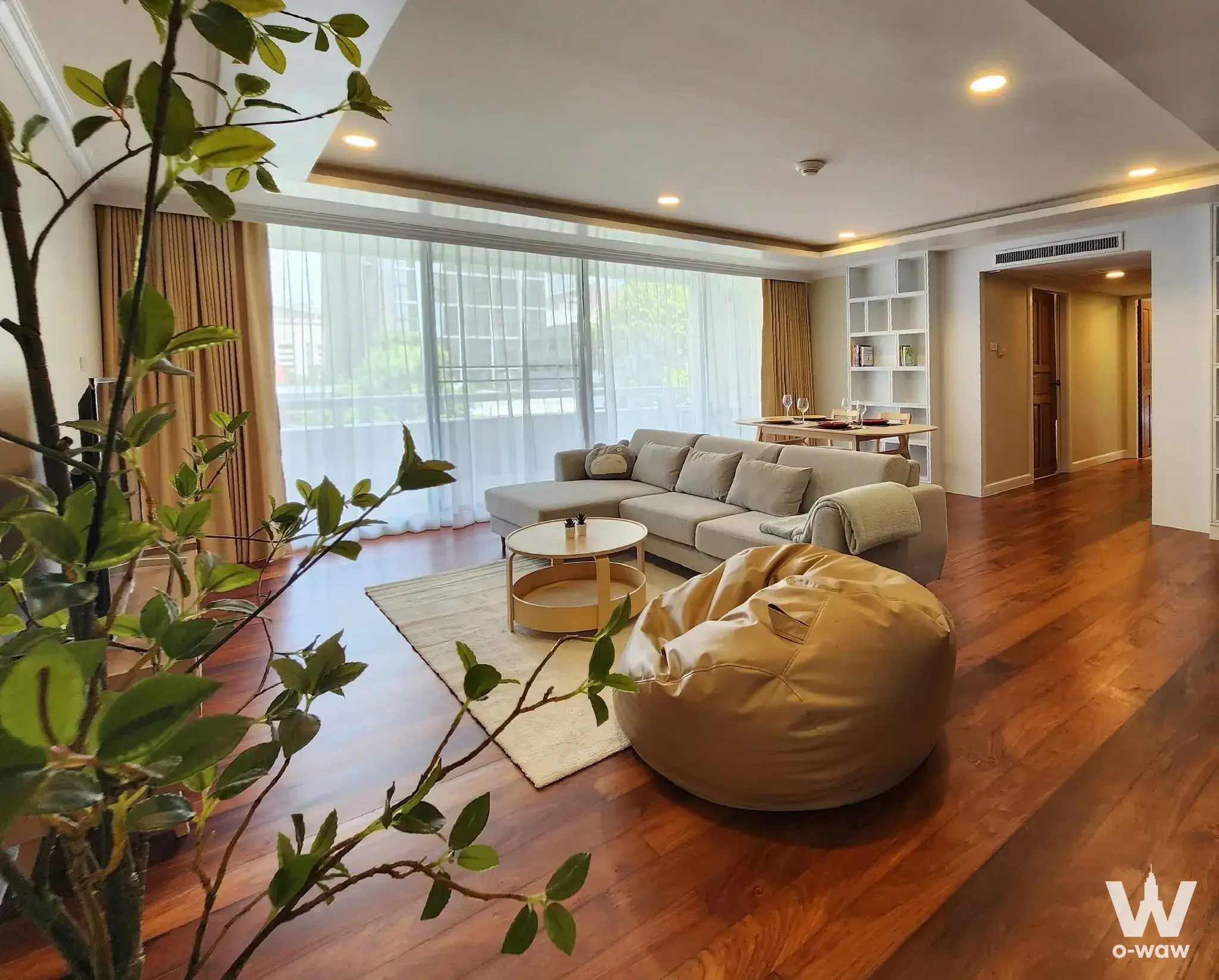 Grey sectional sofa and gold coffee table in the furnished living room of this Somkid Gardens condo