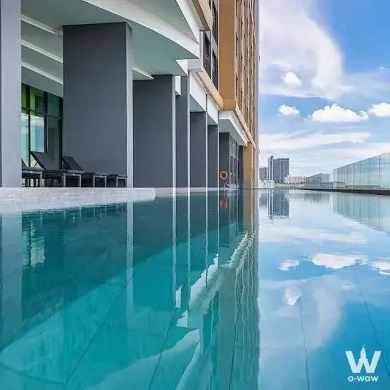 Rooftop infinity pool with city views and lounge chairs at The Niche Mono Sukhumvit 50
