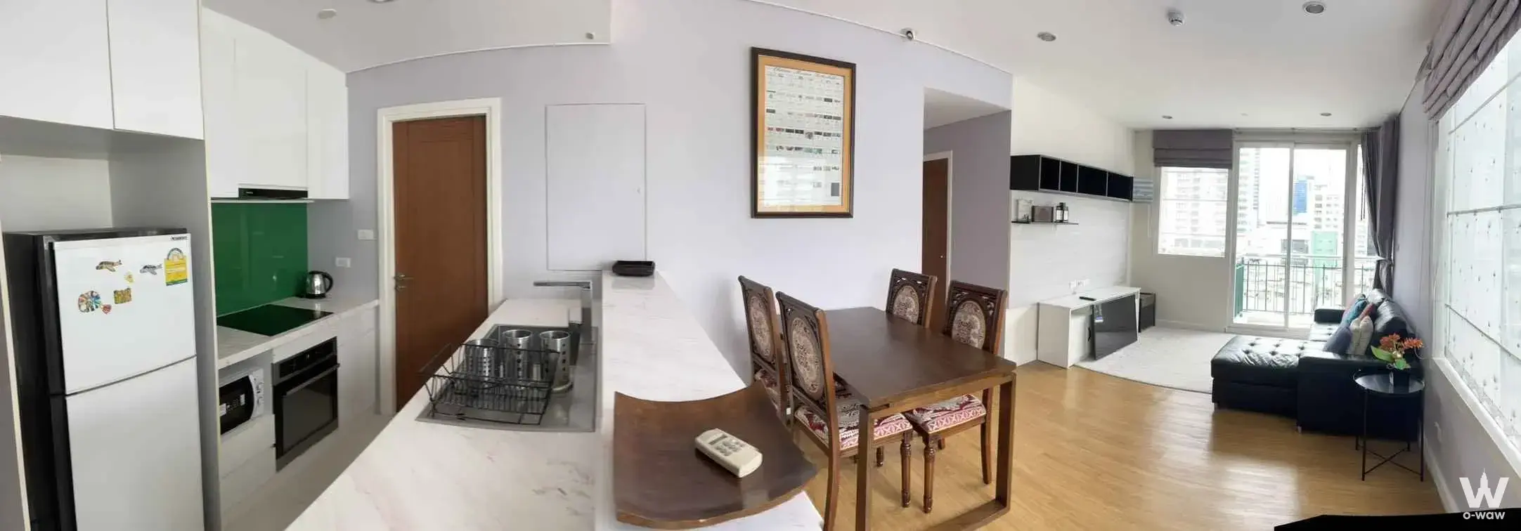 Wind Sukhumvit 23 2-bed condo kitchen with green glass backsplash, marble island, and dining table