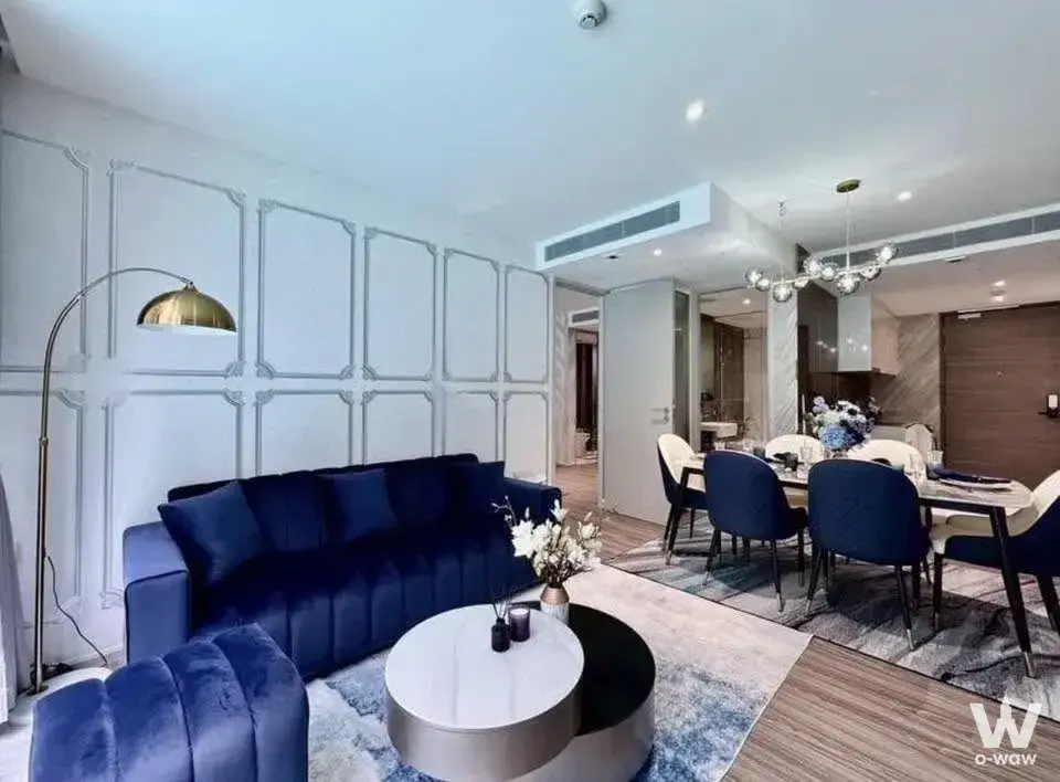 Open-plan living area in Fynn Asoke with navy velvet seating and a modern dining set