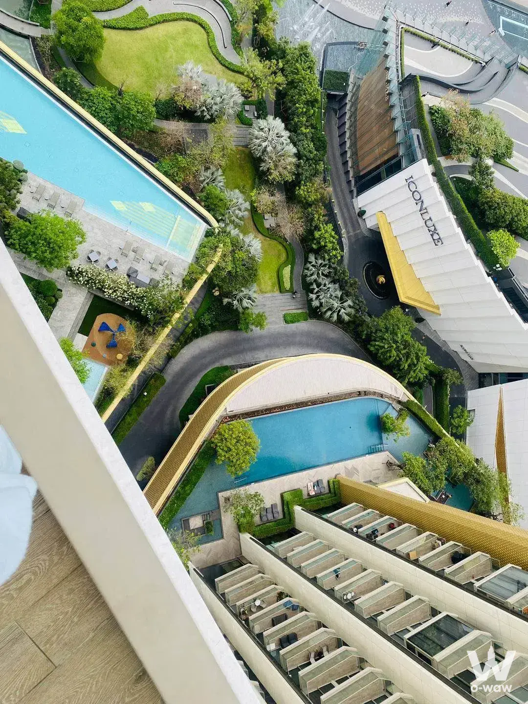 High-floor balcony view of The Residences at Mandarin Oriental pool deck and lush green landscaping