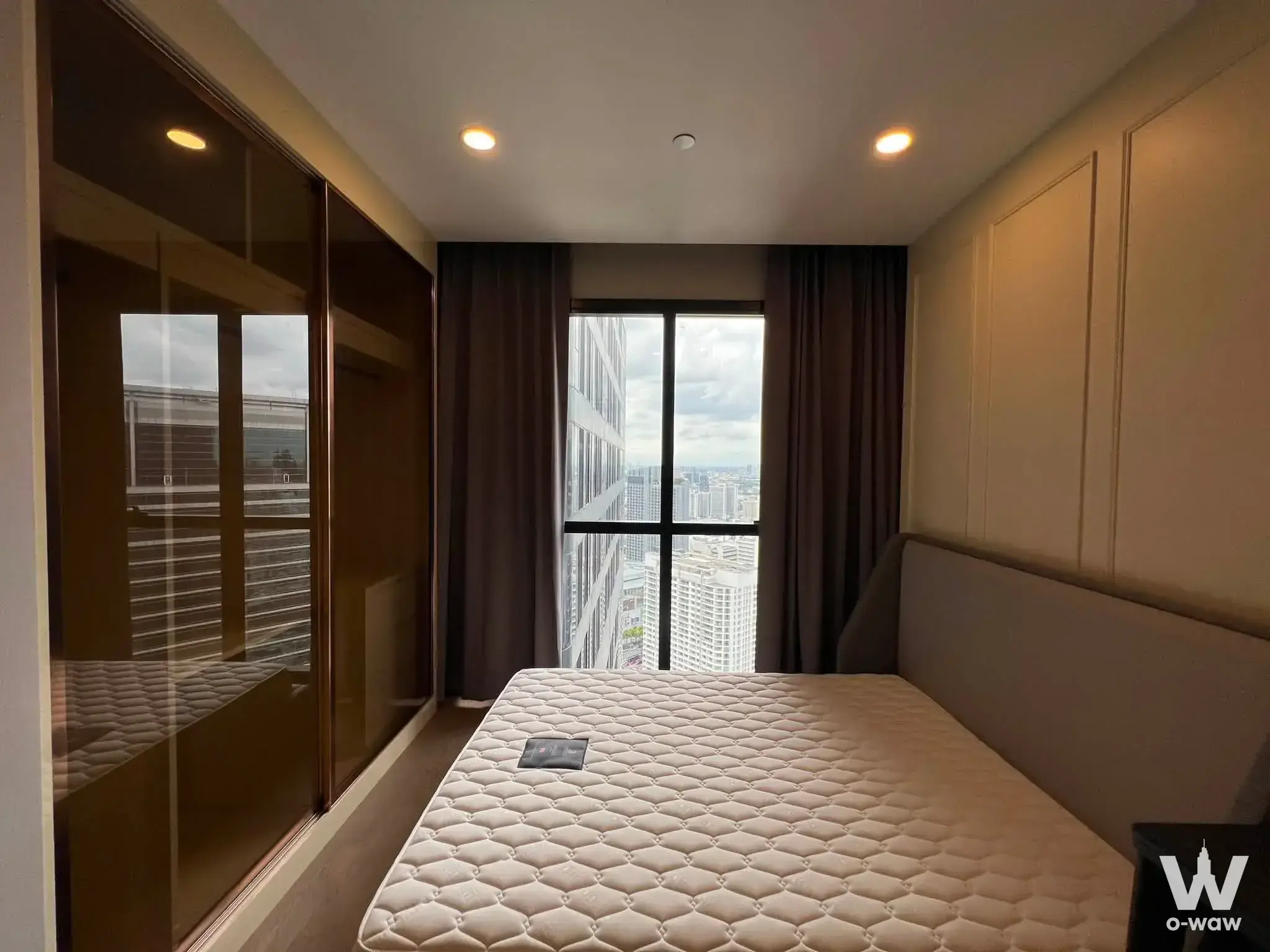 Bedroom with mirrored wardrobe and city view in this 1-bed condo for rent at Ashton Chula-Silom