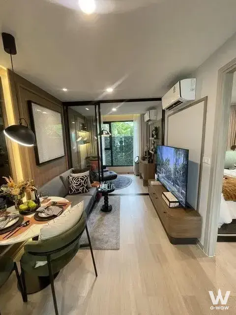 Open-plan living room in a So Origin Sukhumvit 105 condo featuring sage chairs and marble table