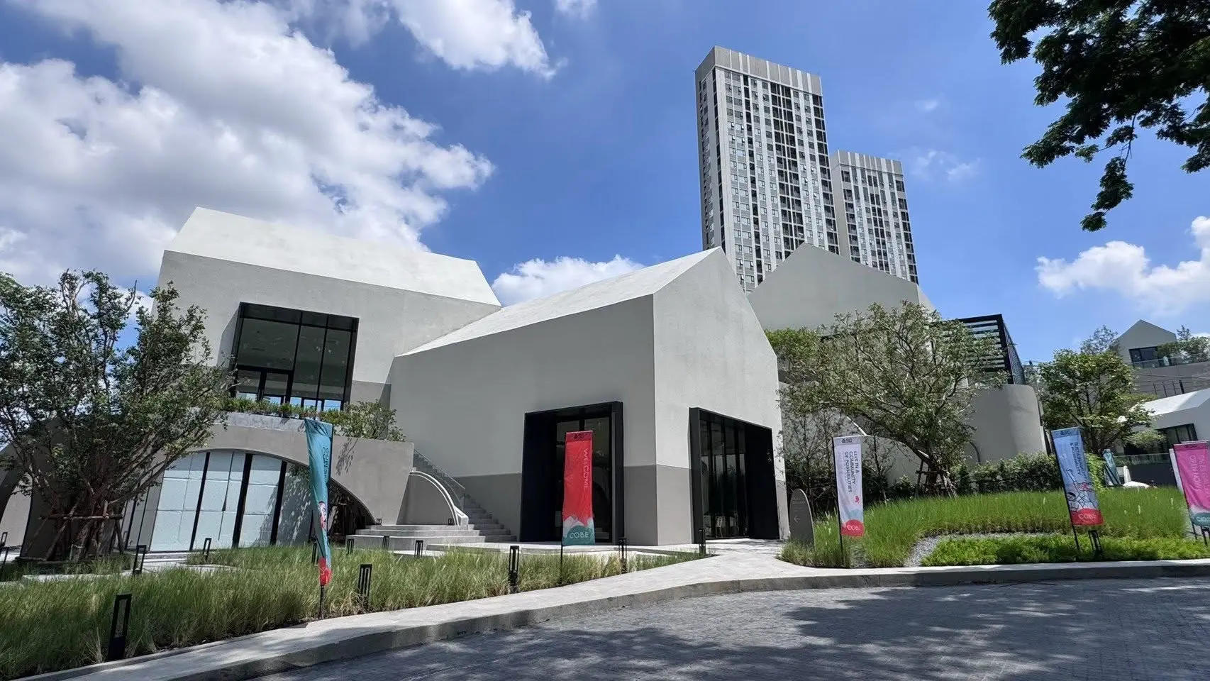 COBE Ratchada-Rama 9 modern condo exterior with white geometric facades and lush landscaping