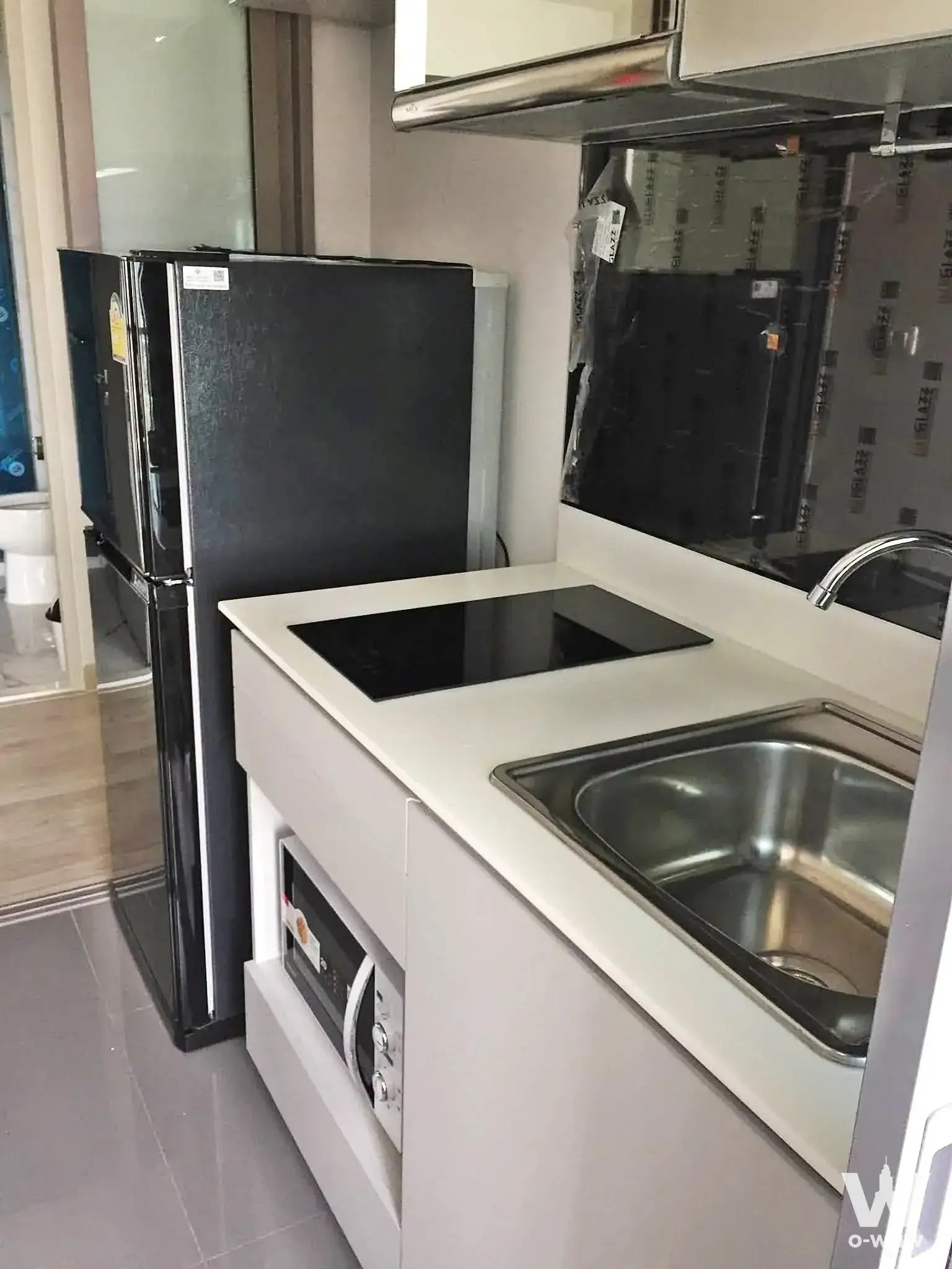 Compact kitchen island with induction cooktop in a 1-bed condo for rent at Niche Pride Tao Poon - Interchange