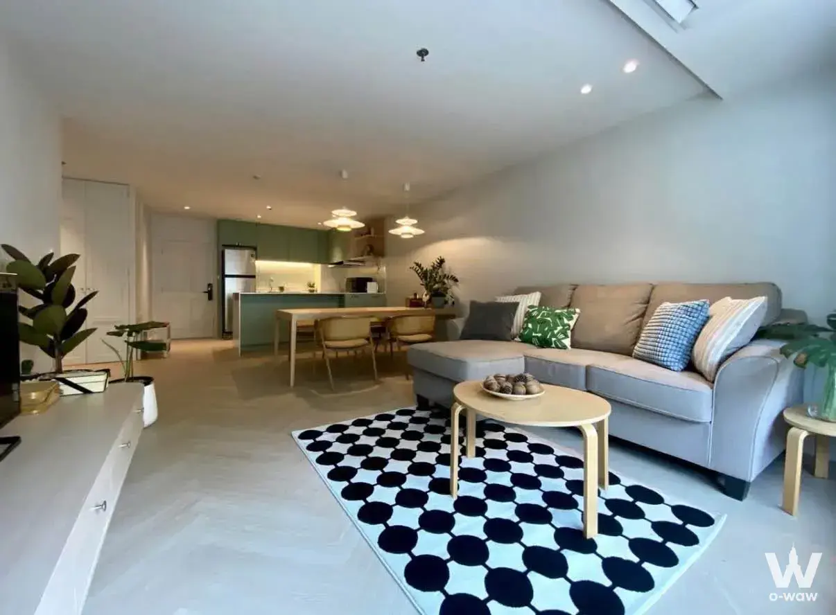 Modern 1-bed condo living area in Baan Ploen Chit with grey sectional sofa and Scandinavian decor