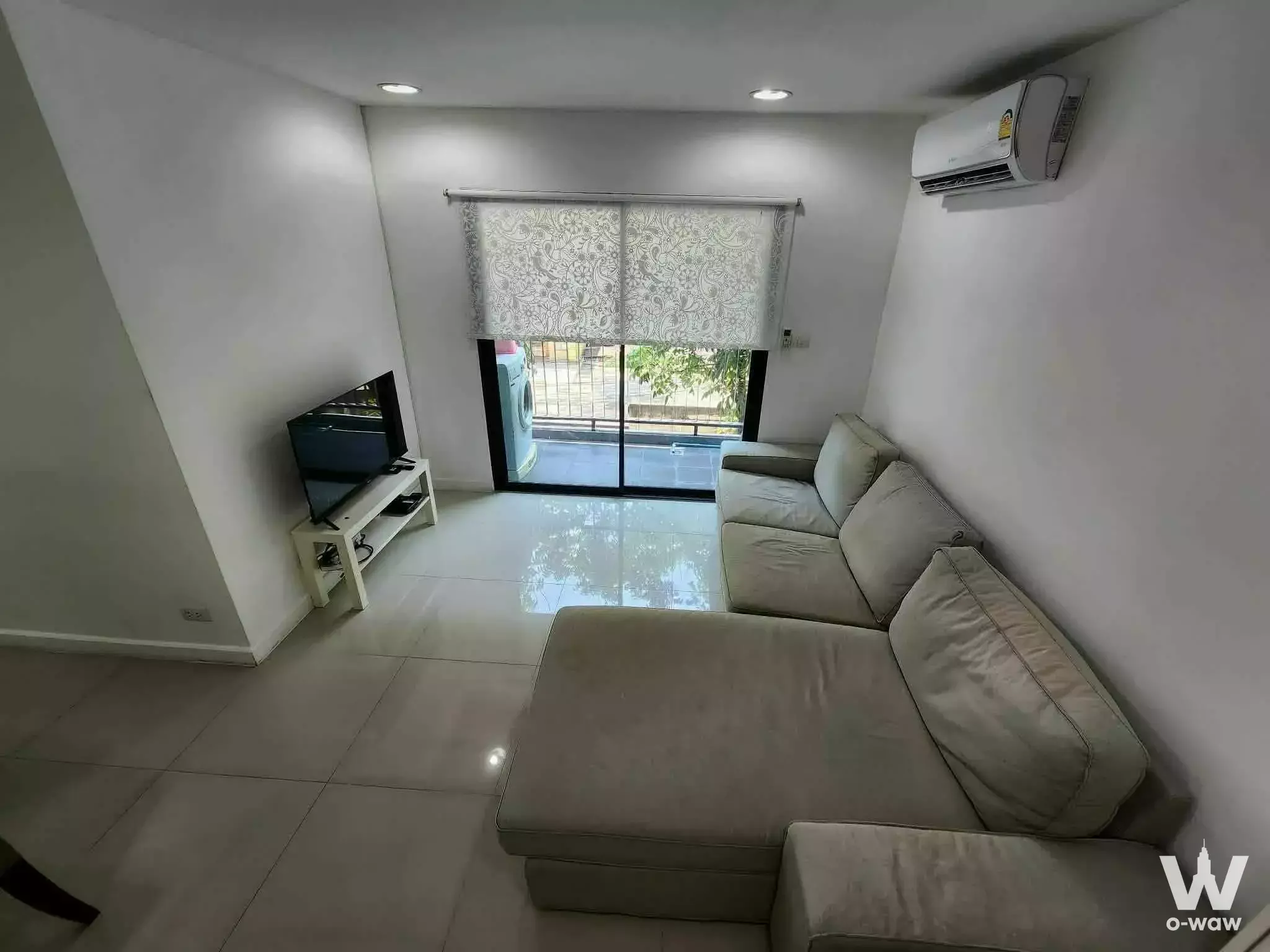 Living room in Zenith Place Sukhumvit 71 with a beige sectional sofa and sliding glass balcony door
