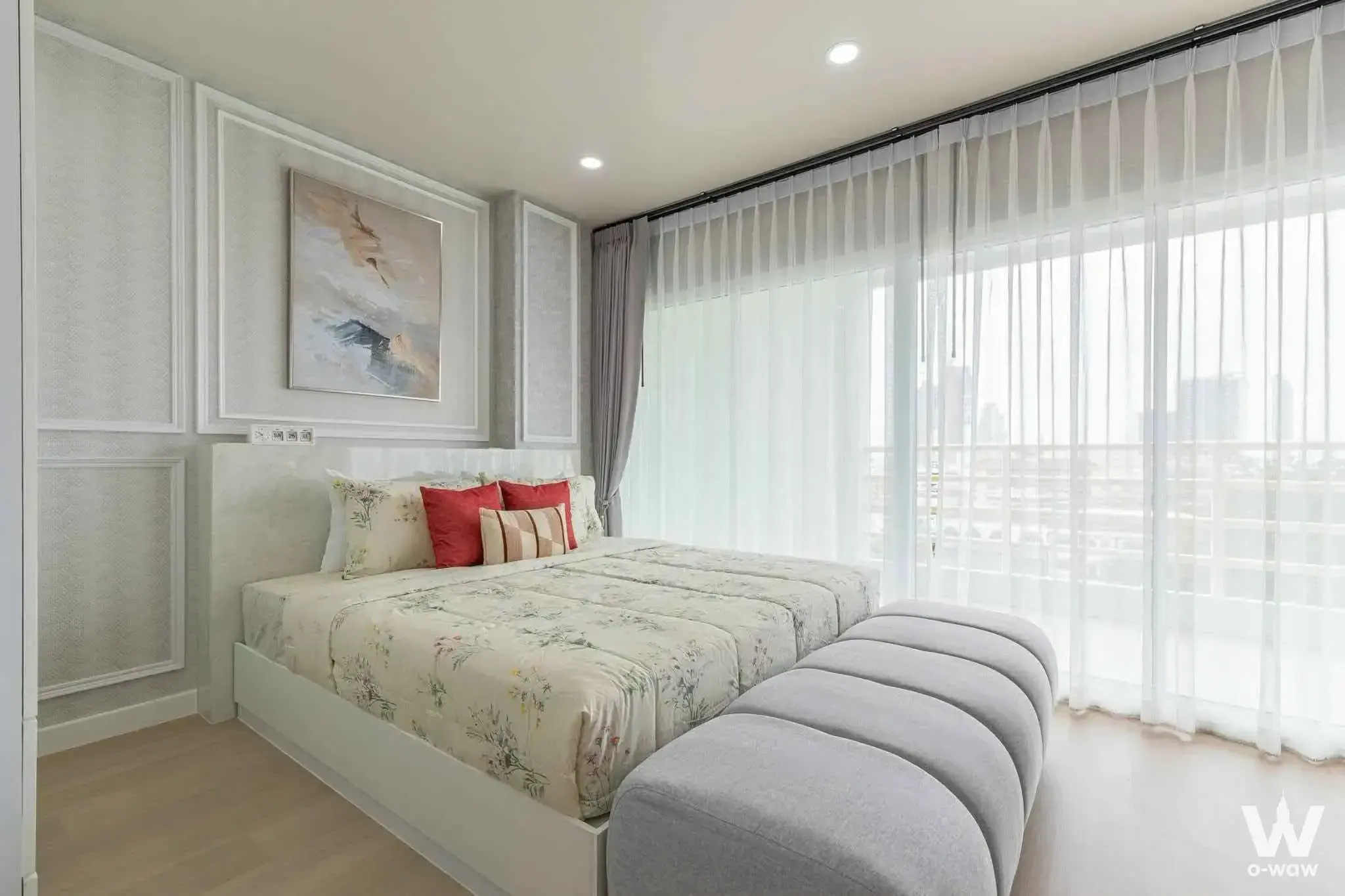Master bedroom with floral bedding and a high-floor city view through sheer curtains at View Talay 5C