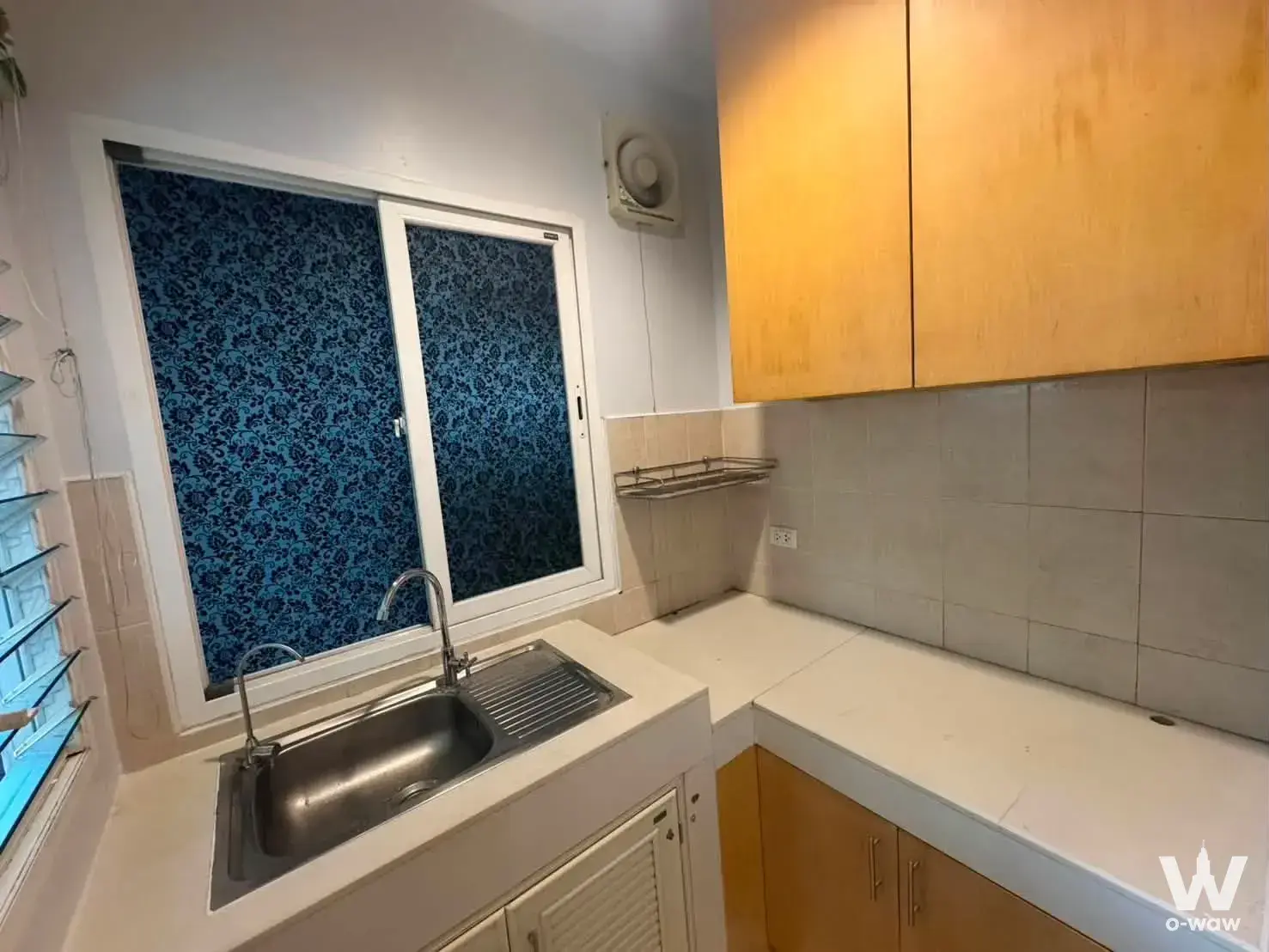 Compact kitchen in Baan Klang Muang Urbanion townhouse with light wood cabinets