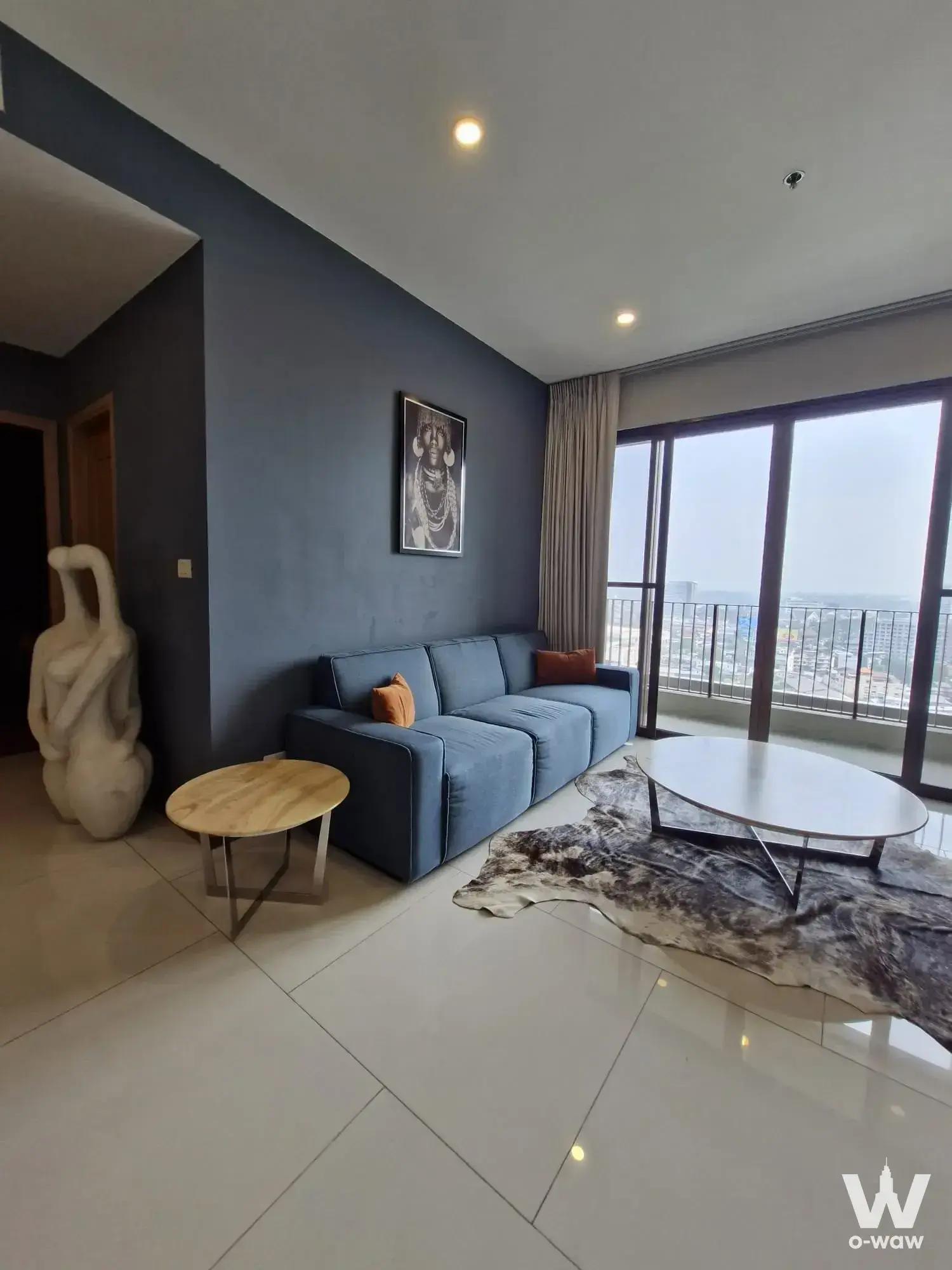 Slate-blue accent wall and city view in a furnished 1-bed condo at The Emporio Place